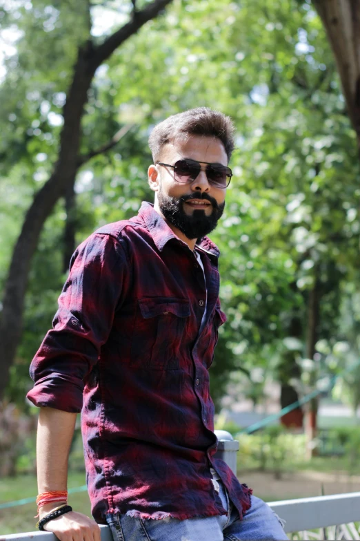 an indian man wearing sunglasses looking to his left