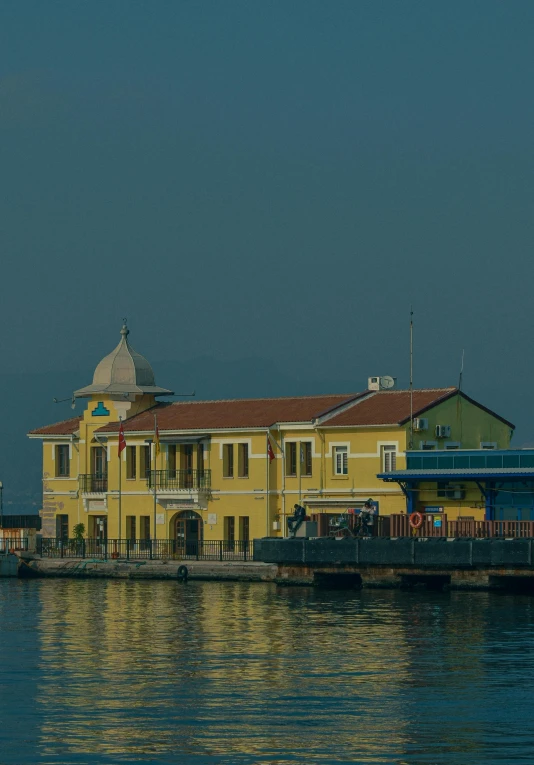 a boat is parked by the dock in front of a yellow building