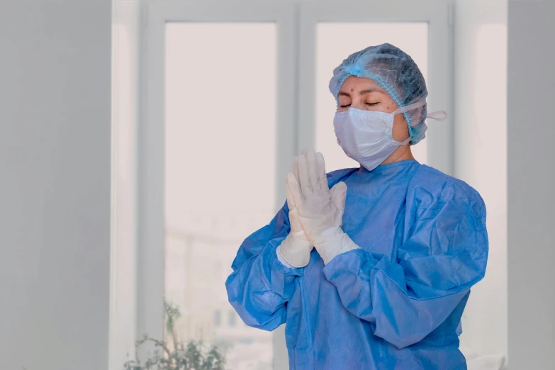 a woman wearing blue clothing and a face mask