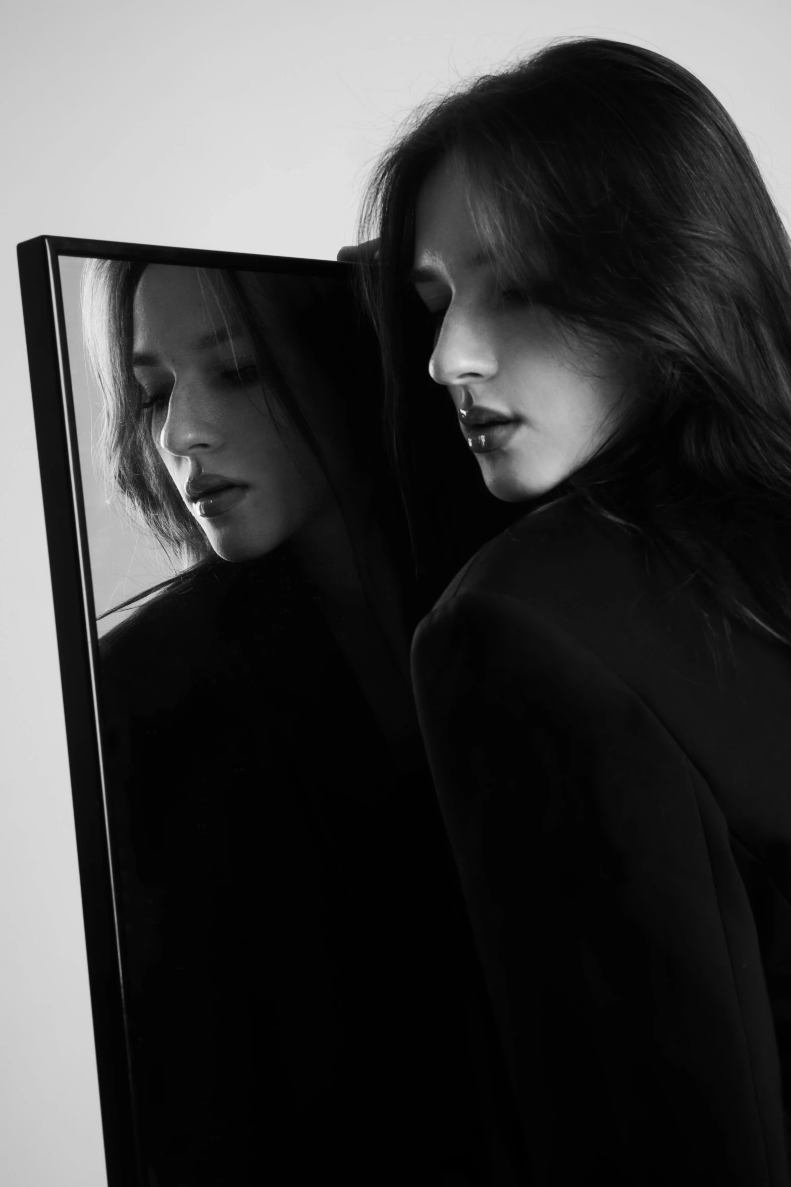 two women looking at their faces in the mirror