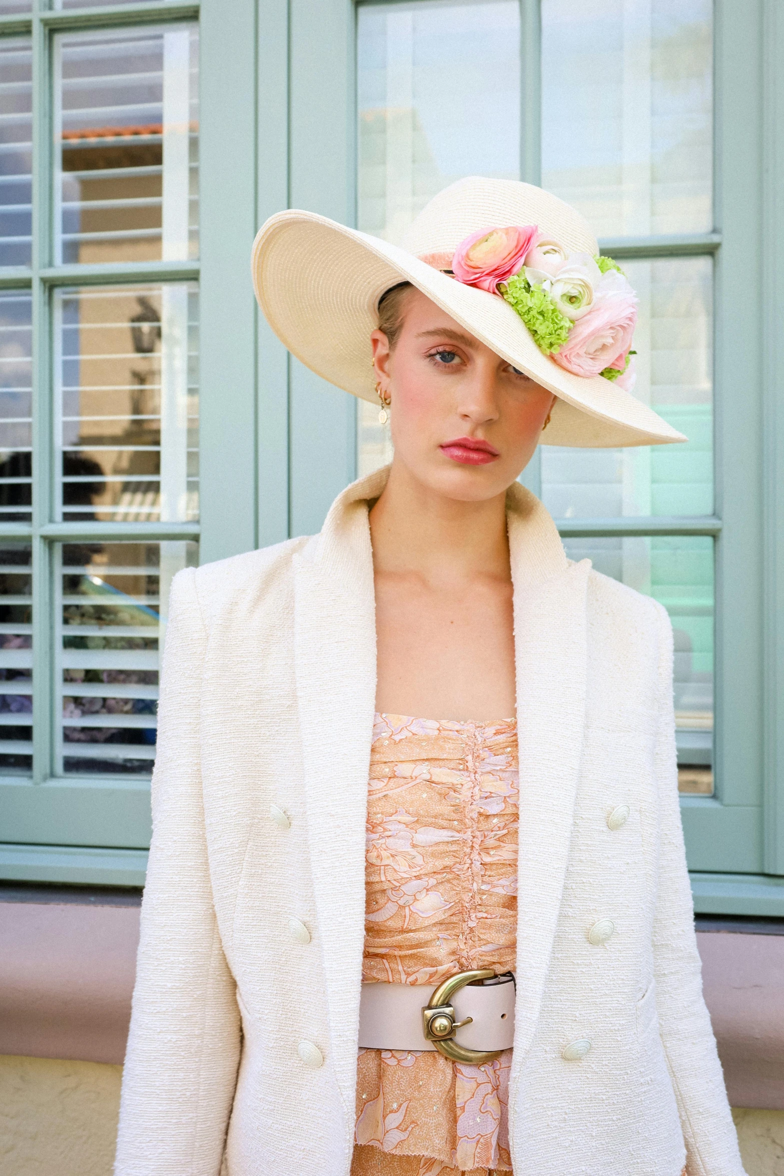 a model wears an unusual hat with a floral design