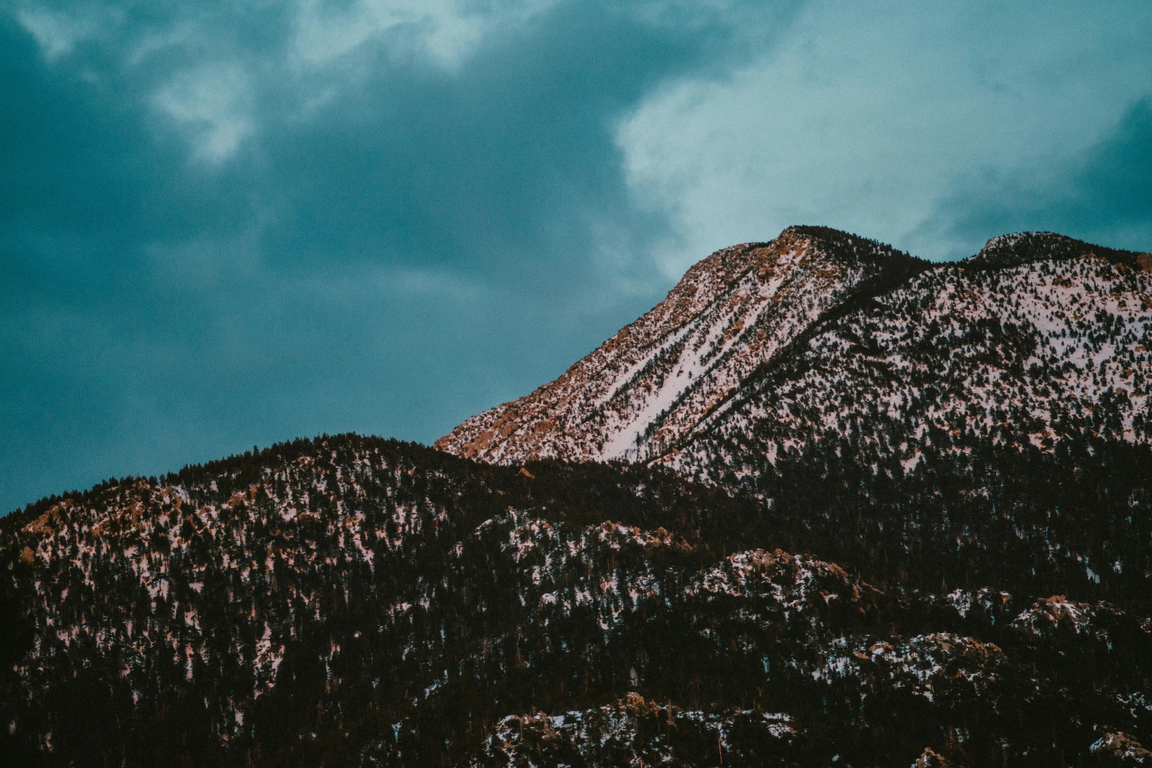 a group of mountains with clouds in the background