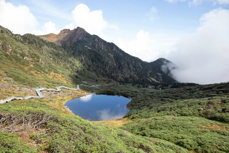 large grassy hill with a lake in it