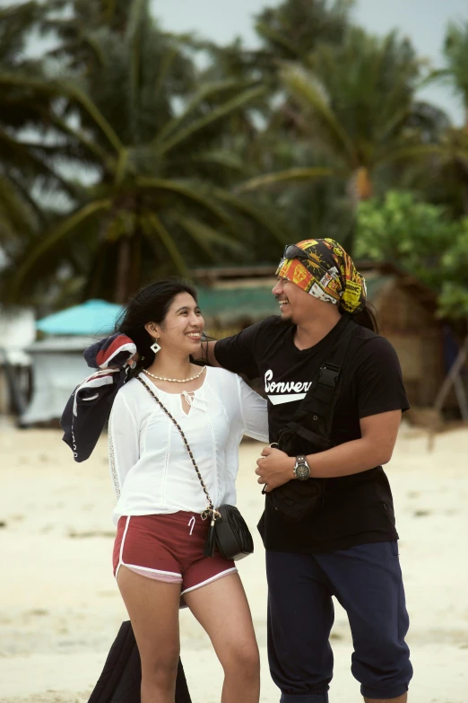 a young woman is walking on the beach talking to a man