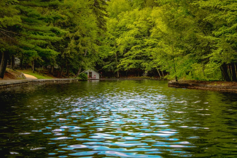 an old stone shelter is on the side of a river