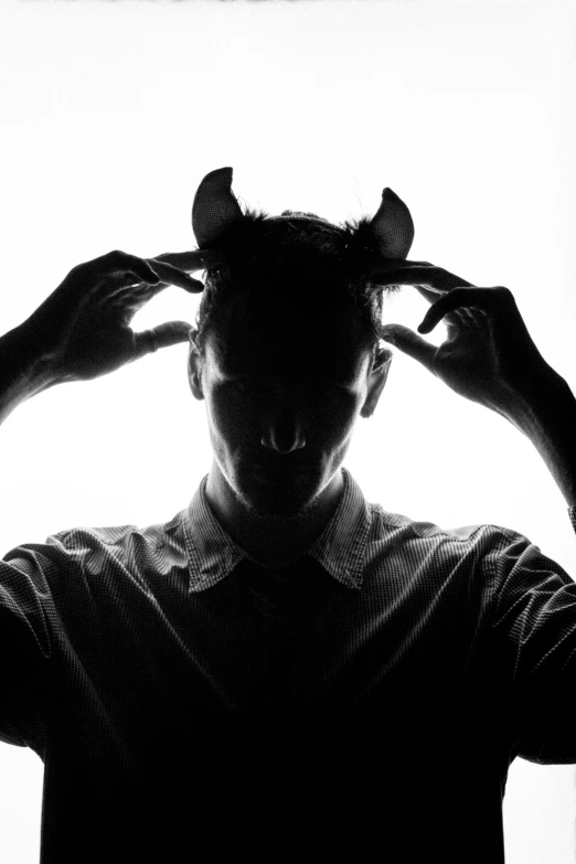 this silhouette is of a person with their hands on his head