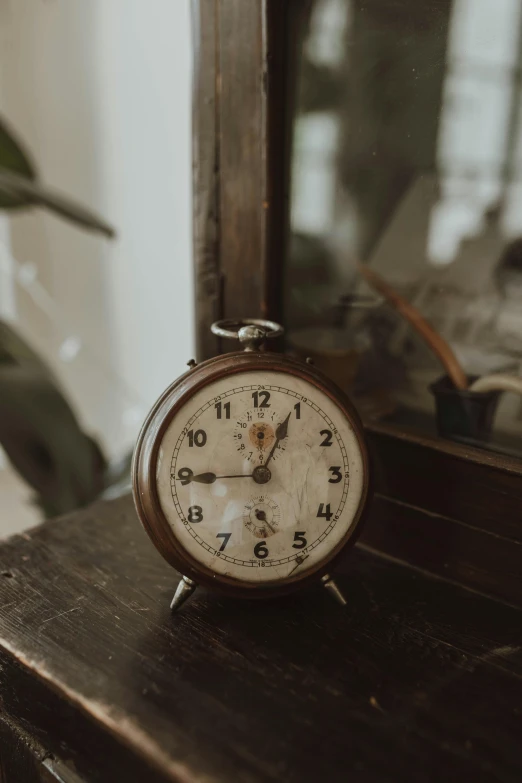 a small brown alarm clock on top of a table