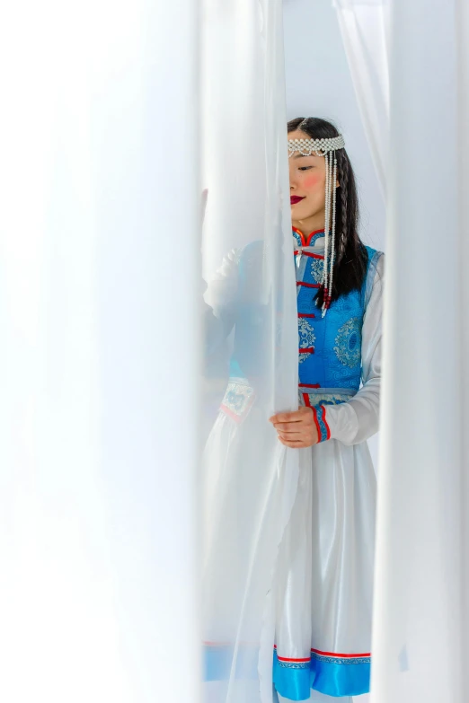 an image of girl in costume hiding behind a curtain