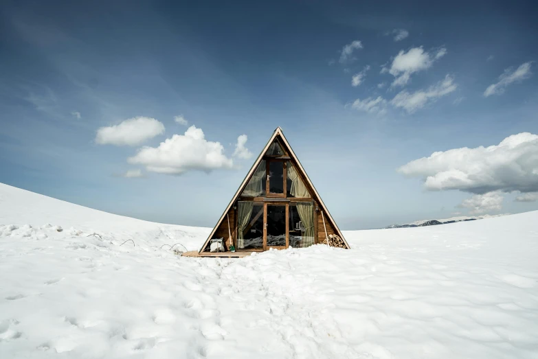 a building sits in the snow on top of a hill