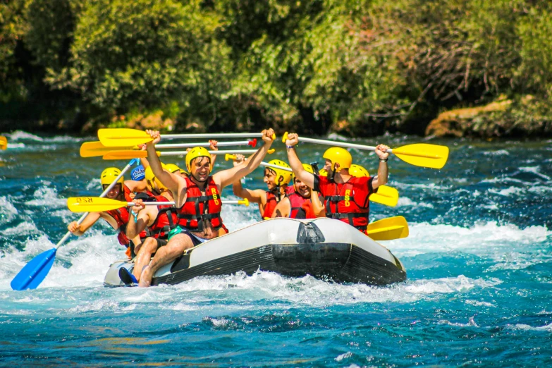 group of men and women riding on rafting down river