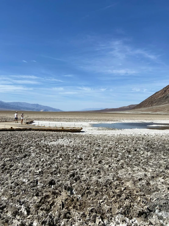 a sandy area with a small lake in the middle