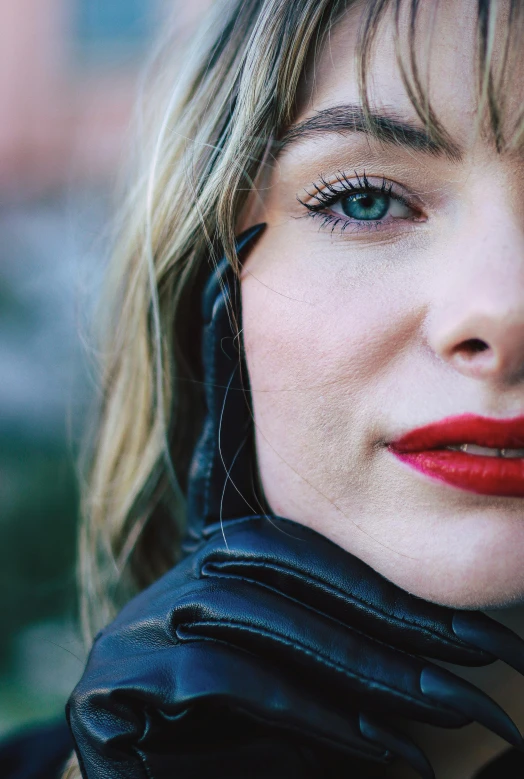 a woman is wearing black gloves and is wearing red lipstick