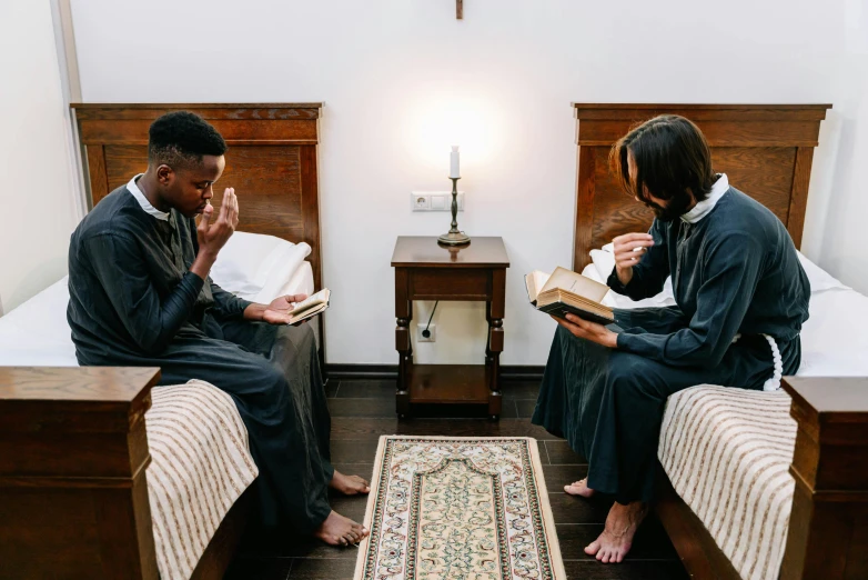 two people sitting on a bed in bedroom next to each other