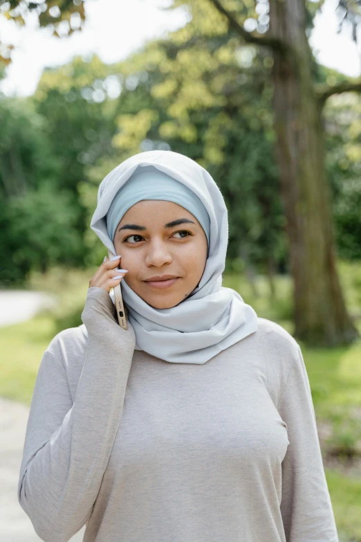 a young woman wearing a scarf talking on her cell phone