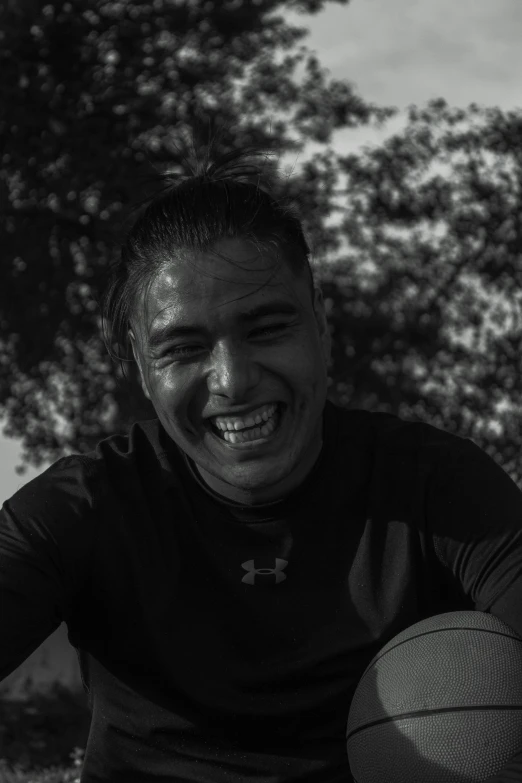 a man is playing basketball outside in a black and white po