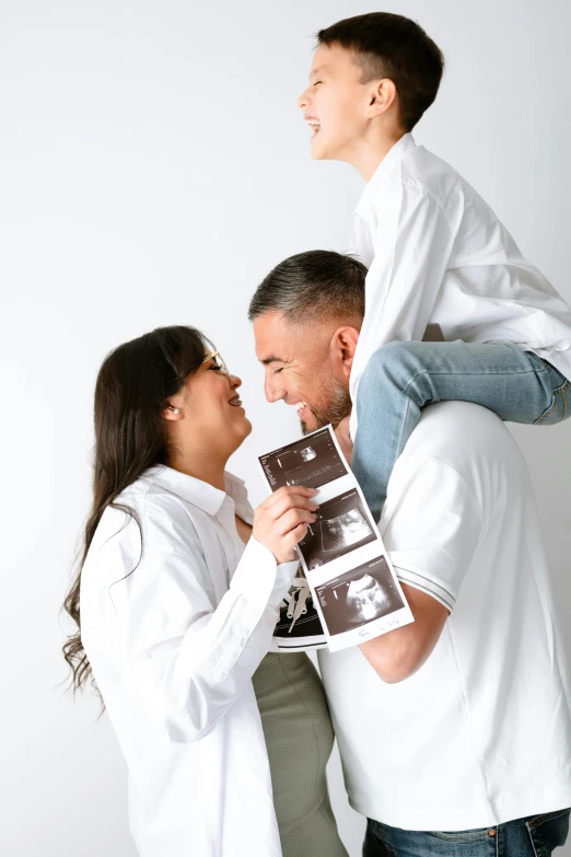 a man and woman standing next to each other holding pictures