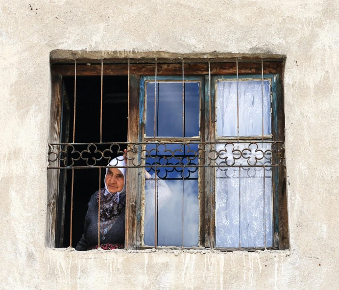 woman looking out a window of an old building