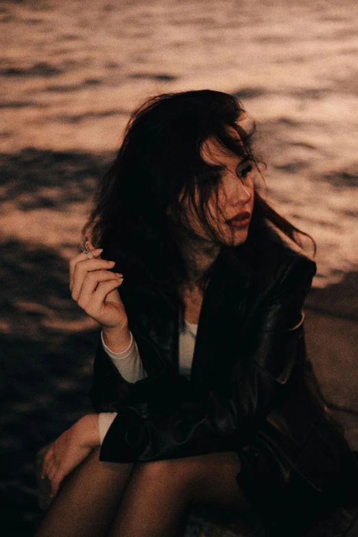 a woman is sitting near the water and crying