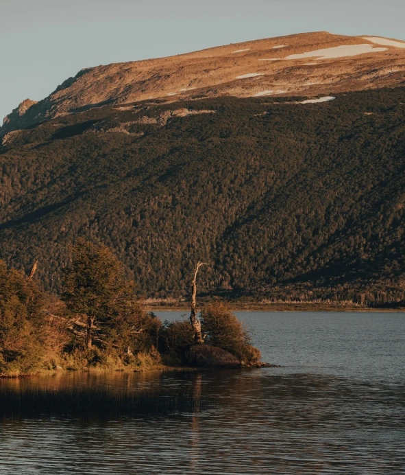 a lake surrounded by mountains with small island