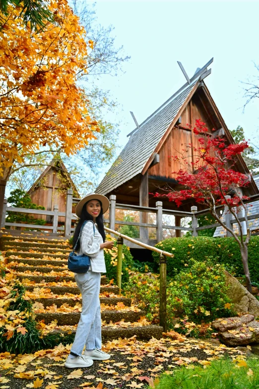 a woman that is standing in front of some leaves