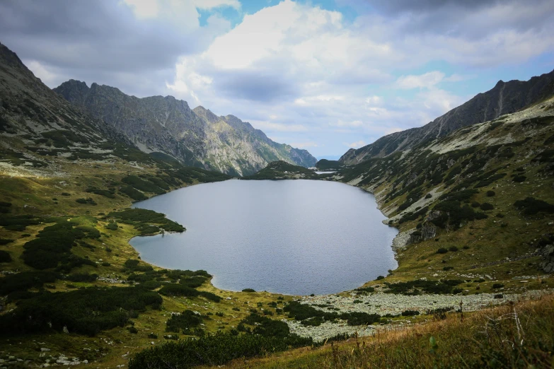 a small lake surrounded by mountains that's in the middle of nowhere