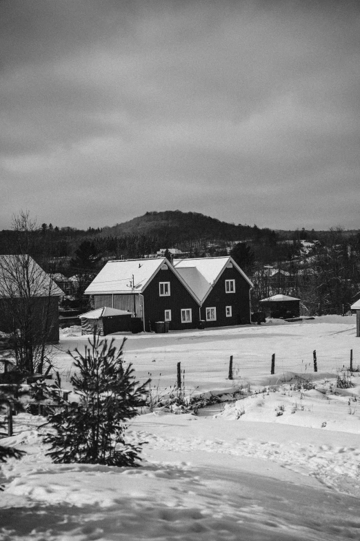 a couple houses are covered in snow with mountains in the background