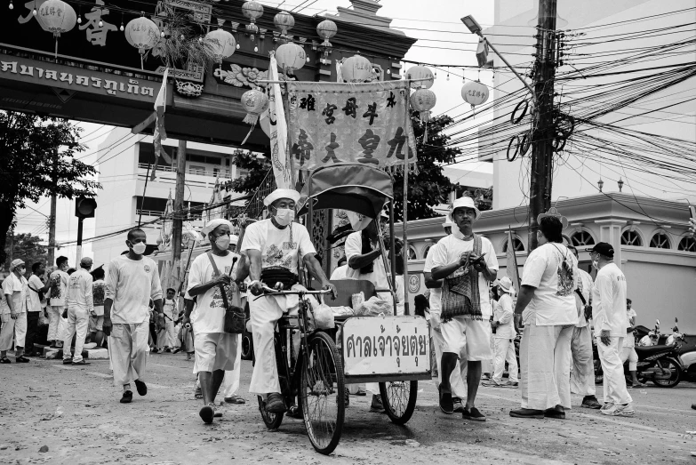 black and white pograph of people on bike passing by