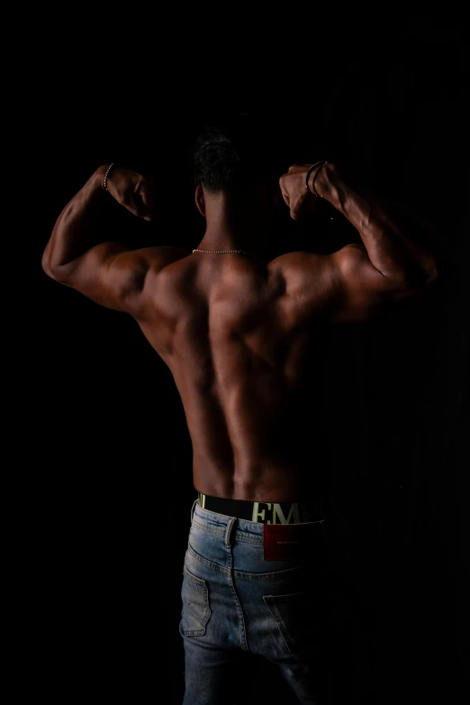 a man standing and flexing his back muscles