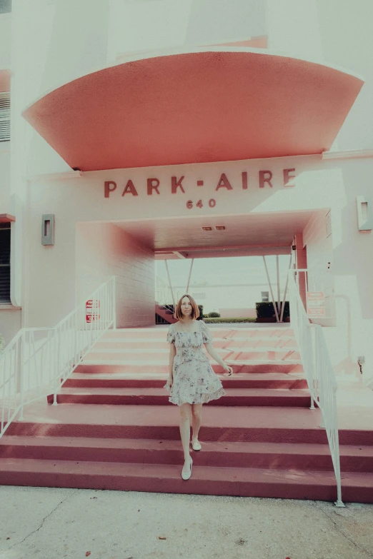 a woman posing on a set of steps in front of a building