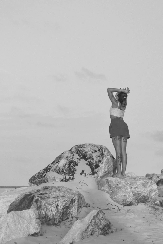 a woman in a bikini standing on some rocks