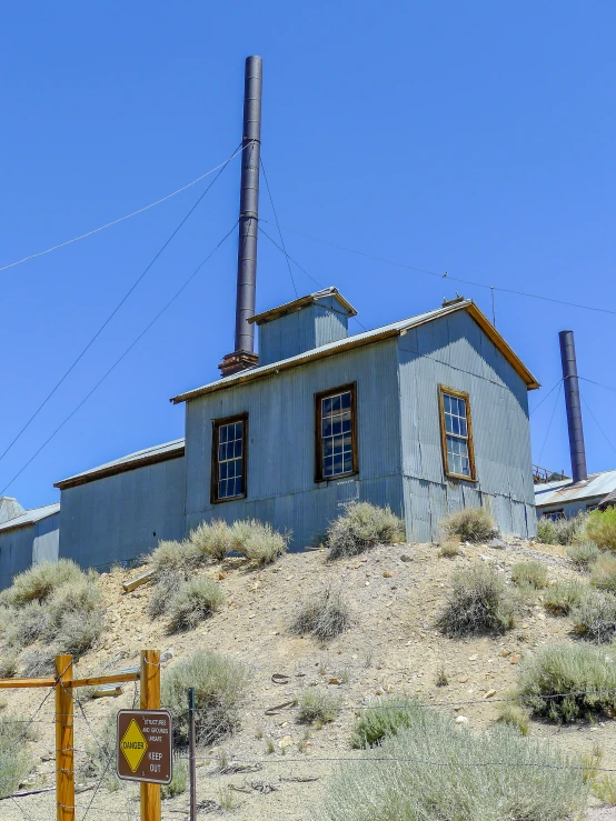 an old house with many windows sits on a mountain