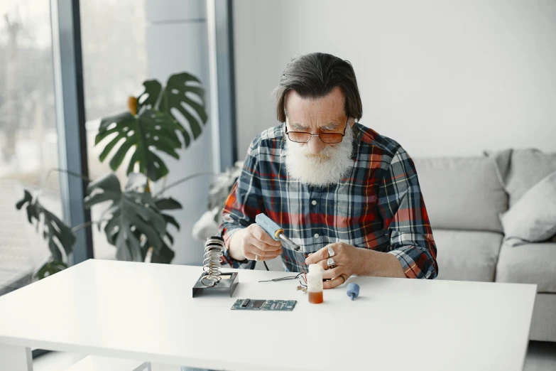 a man sits at a table with a white beard