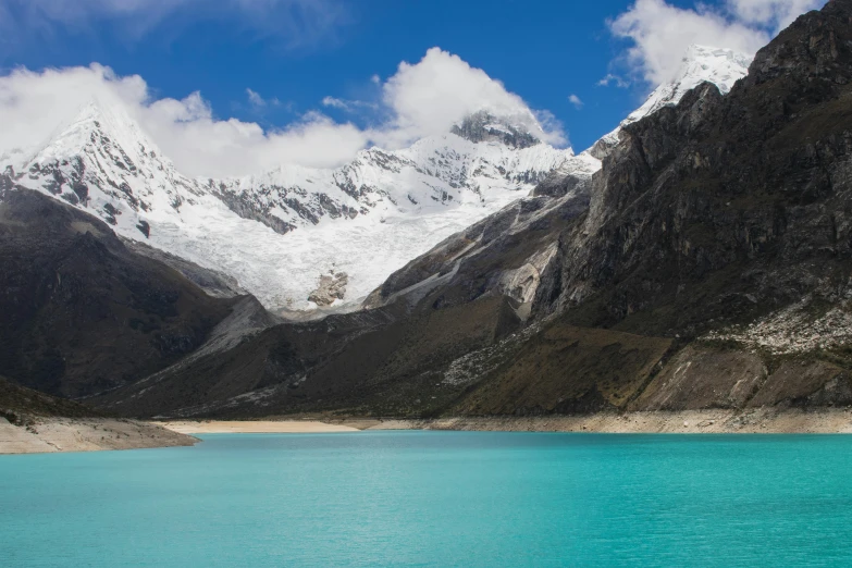 the snow covered mountains are above a body of water