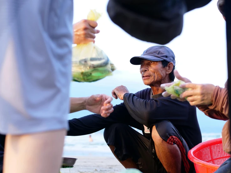 a group of people with fruits in their hands on the beach