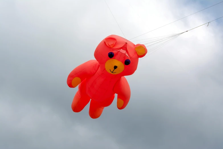 there is a large red bear kite flying in the air