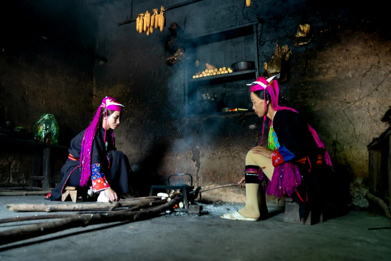 two women sitting on the ground in colorful robes