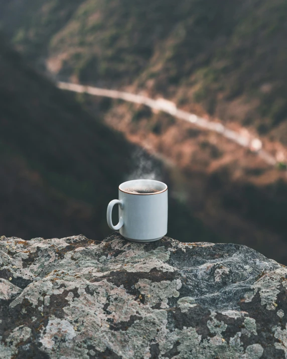 a cup that has smoke in it sits on top of a mountain