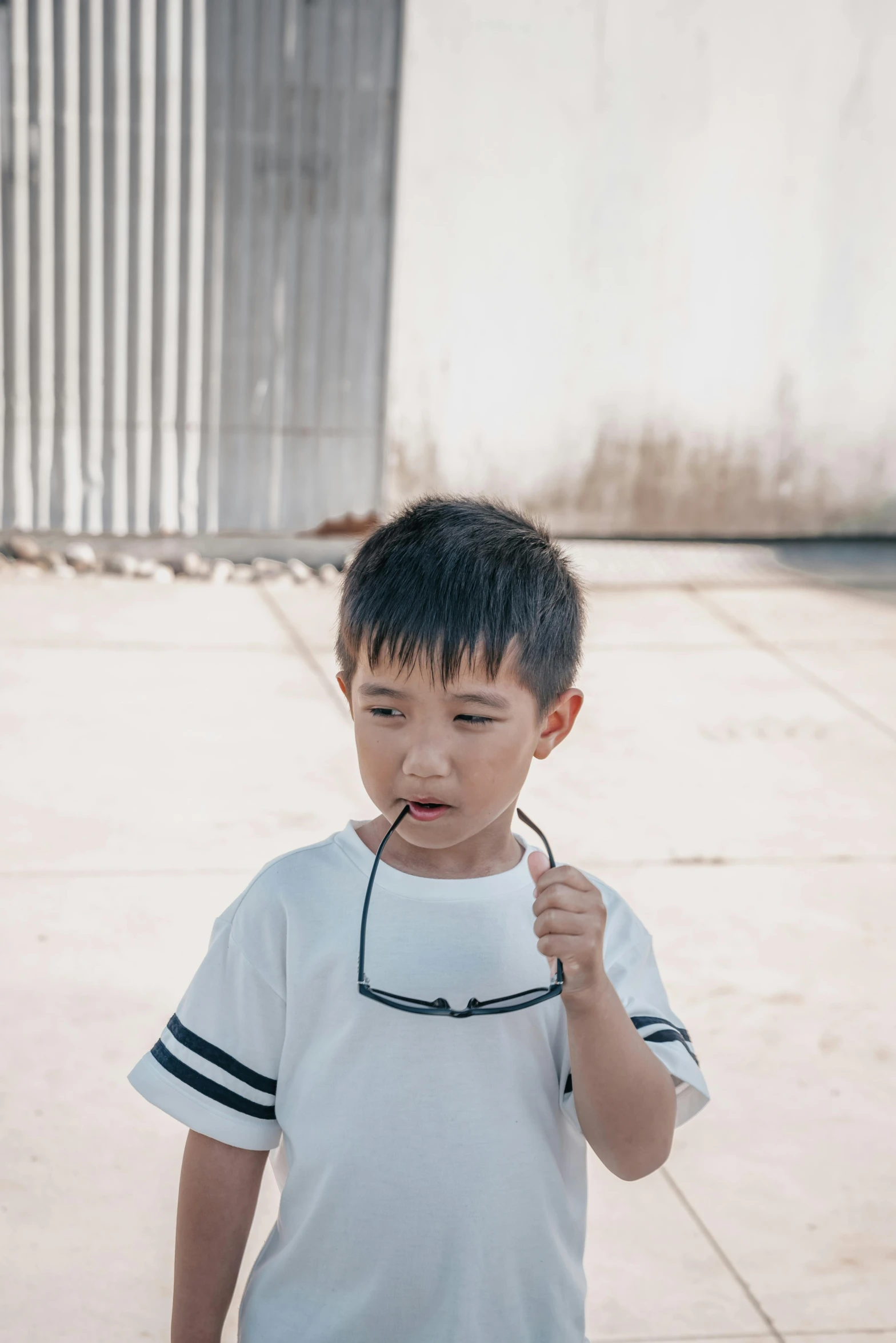 a little boy brushing his teeth outside in the daytime