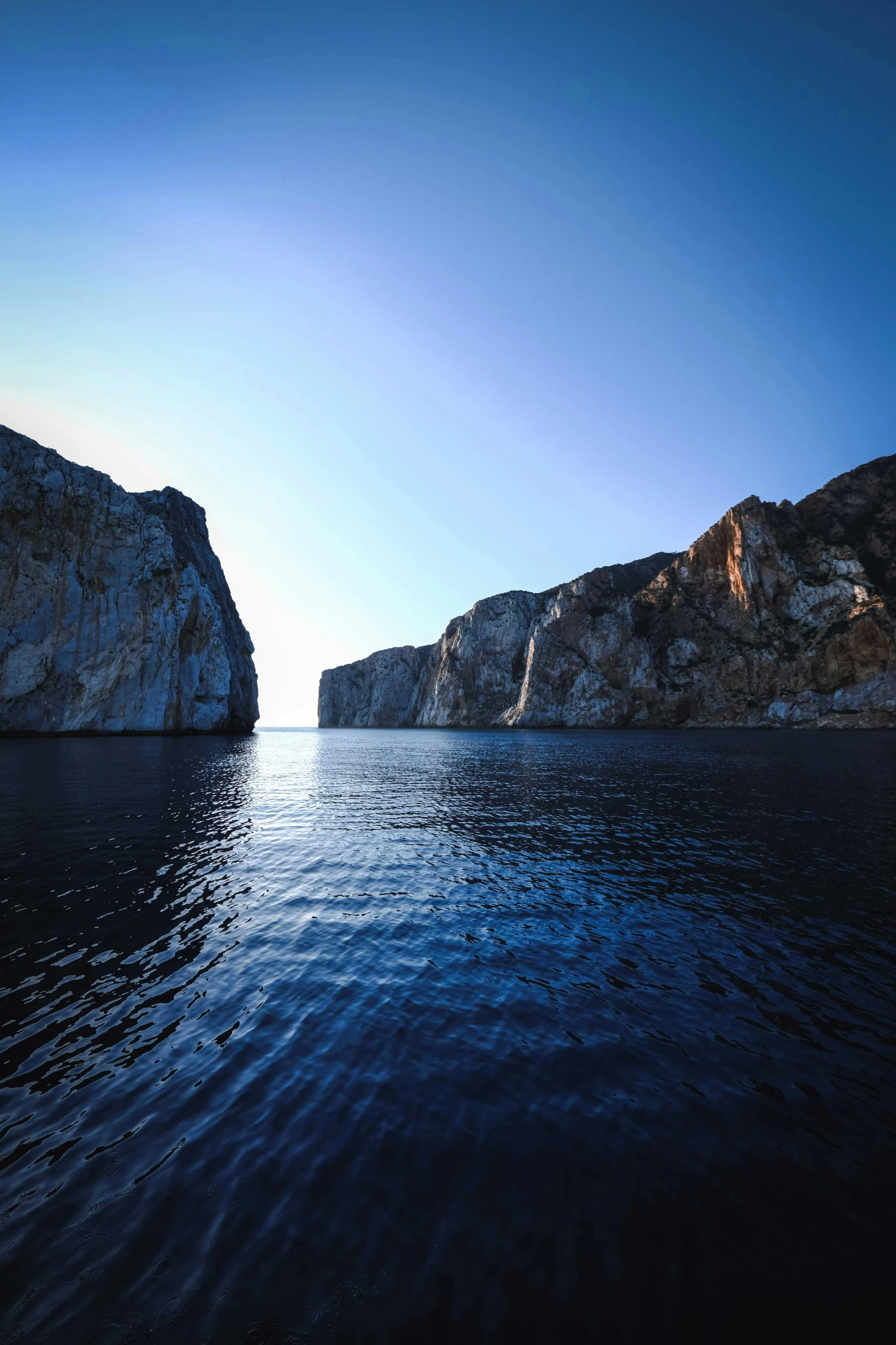 a large rocky cliff sitting on top of a body of water