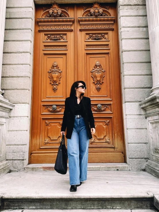 a woman is walking outside of a very ornate door