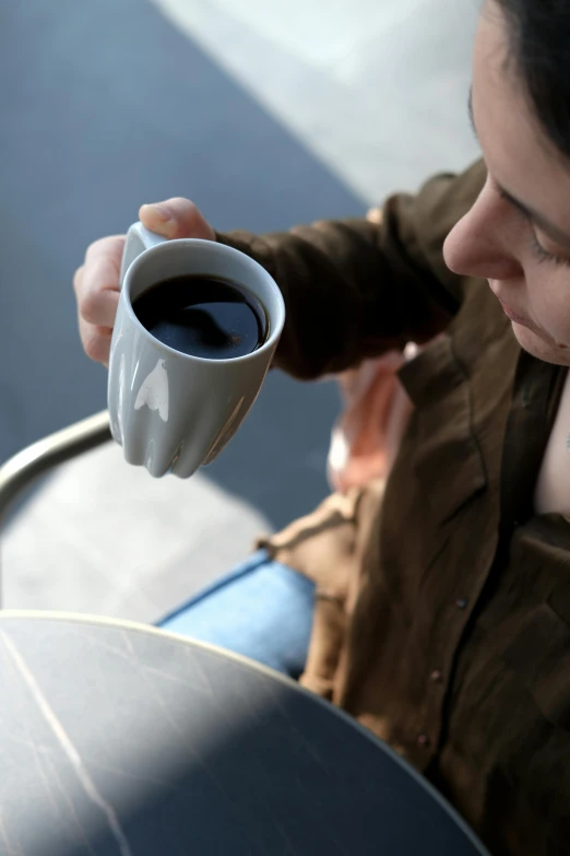 there is a woman holding a cup of coffee