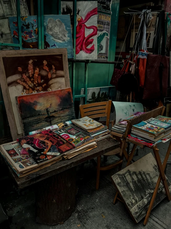 a table topped with lots of different paintings