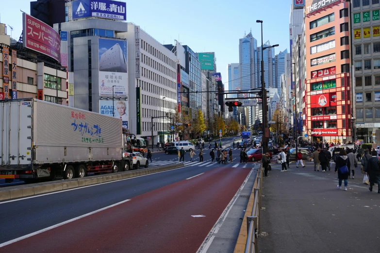 the street in a city with pedestrians and buses on both sides