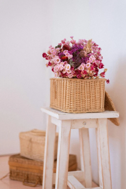 a flower arrangement sits in the center of a stool
