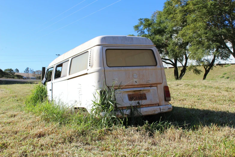 an old van sitting in a grassy field