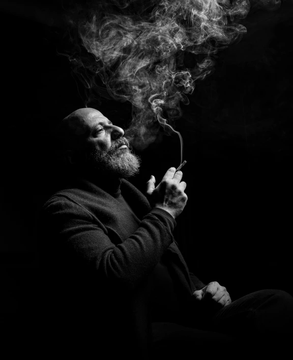 a man sitting in the dark smoking a pipe