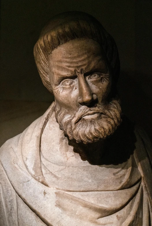 a man statue sitting next to a black wall