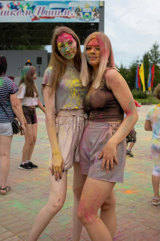 two young women covered in colors and face paint