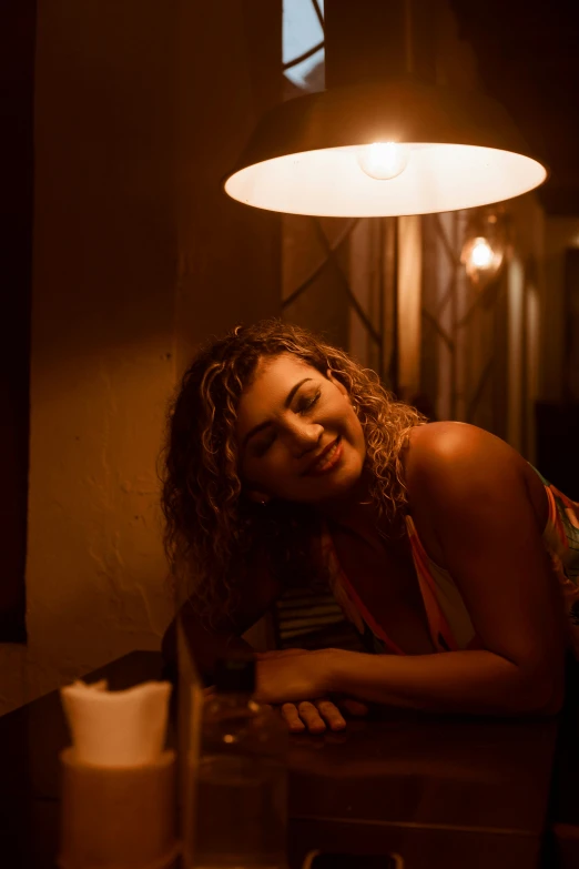 the young woman smiles brightly while leaning on a bar