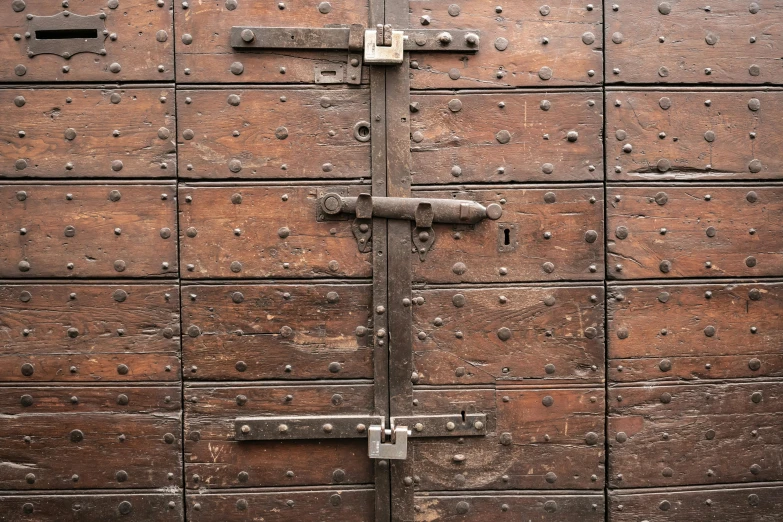 a large, wooden door is open with rivets